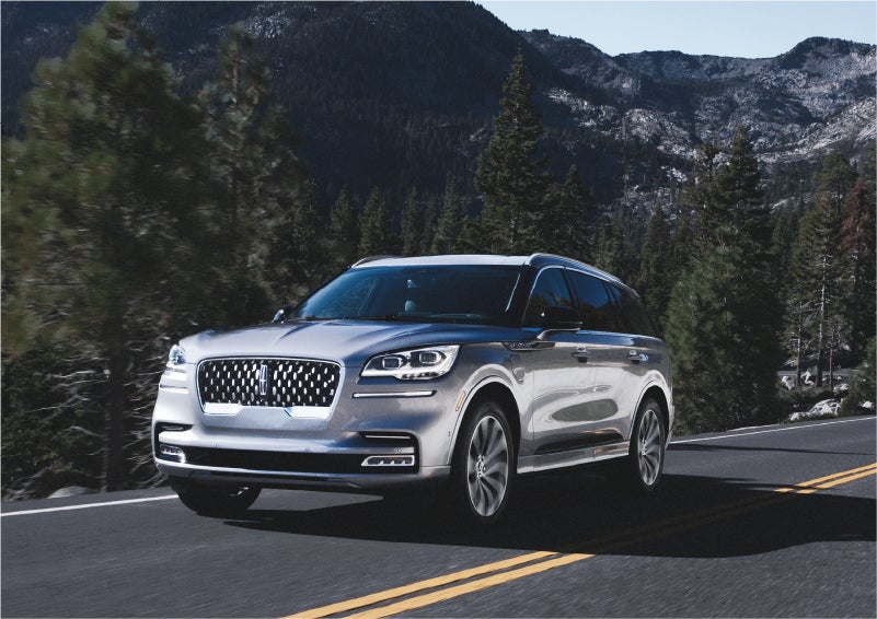 A 2023 Lincoln Aviator® Grand Touring SUV being driven on a winding road to demonstrate the capabilities of all-wheel drive | Hines Park Lincoln in Plymouth MI