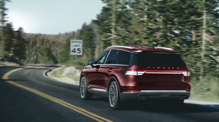 A 2024 Lincoln Aviator® SUV is being driven on a winding mountain road | Hines Park Lincoln in Plymouth MI