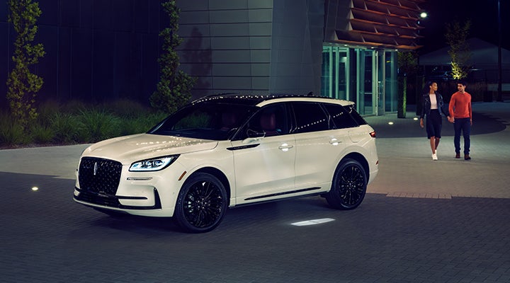 Two people approach a 2024 Lincoln Corsair® SUV featuring the available Jet Appearance Package. | Hines Park Lincoln in Plymouth MI