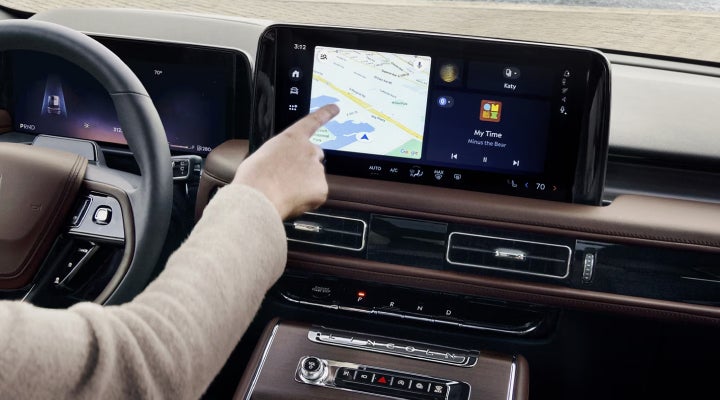 A person is tapping the center display touchscreen of a 2026 Lincoln Aviator® SUV. | Hines Park Lincoln in Plymouth MI