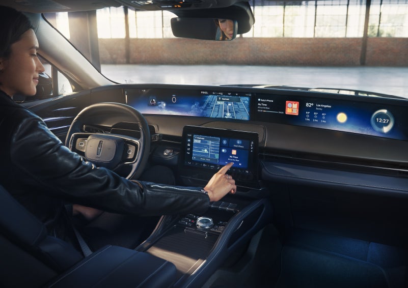 The driver of a 2026 Lincoln Nautilus® SUV interacts with the center touchscreen. | Hines Park Lincoln in Plymouth MI