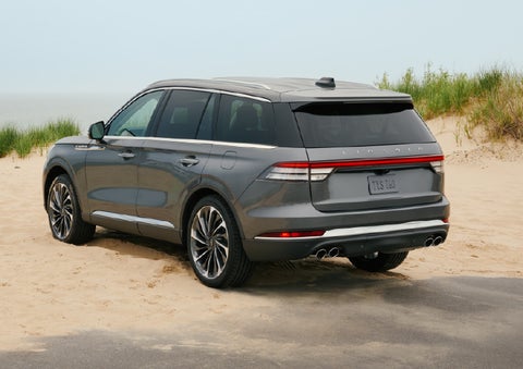 A 2027 Lincoln Aviator® SUV is parked next to sand dunes. | Hines Park Lincoln in Plymouth MI