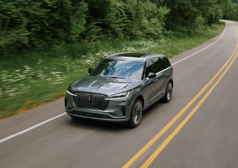 A 2027 Lincoln Aviator® SUV is being driven down a road. | Hines Park Lincoln in Plymouth MI