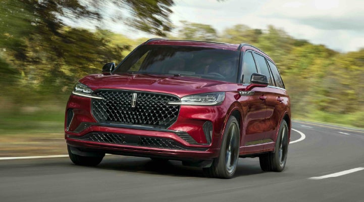 A 2027 Lincoln Aviator® SUV is being driven on a country road | Hines Park Lincoln in Plymouth MI