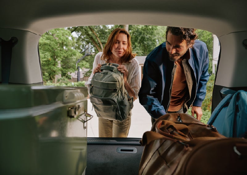 A couple loads luggage into the rear of a 2027 Lincoln Aviator® Black Label™ SUV..e 202 | Hines Park Lincoln in Plymouth MI