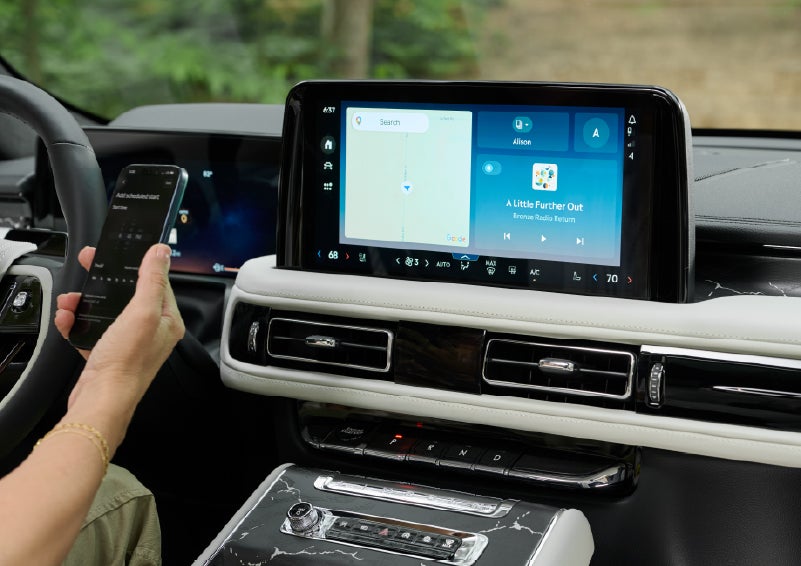 A person pairs thier phone with the center touchscreen of a 2027 Lincoln Aviator® Black Label™ SUV | Hines Park Lincoln in Plymouth MI