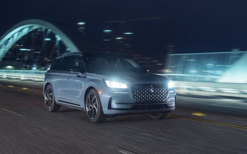 Lincoln Corsair Grand Touring SUV driving along bridge at night