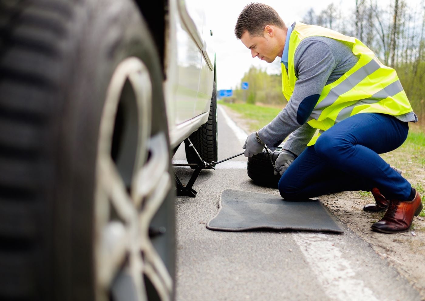 Certified Lincoln Technician working on Lincoln vehicle on side of road with Lincoln Mobile Service